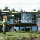 Large glassed face building with totem pole        