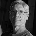 a photo of a prairie landscape with metal rods coming out the top and bottom, and a photo of a man with glasses