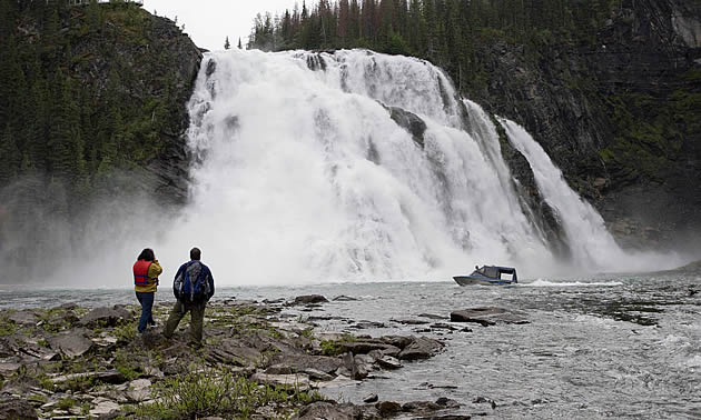 man and woman standing beside a waterfall