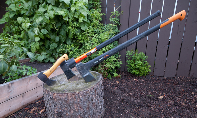 The author's three favourite axes are dug into a stump.