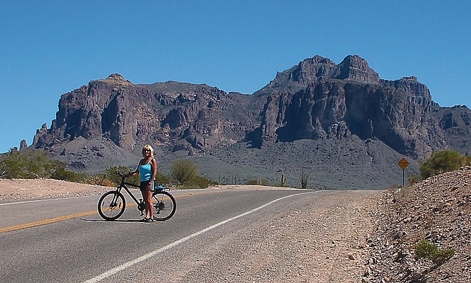 woman on a bike with mountains in the background