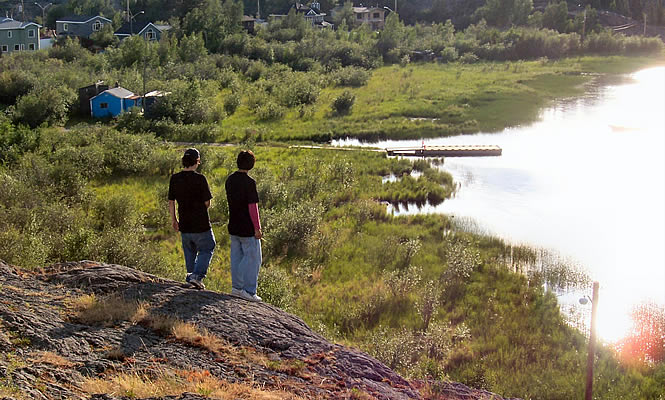 two people standing beside a pond