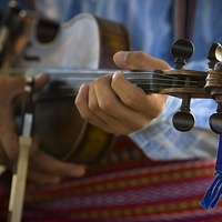 A close up photo of someone playing a violin.