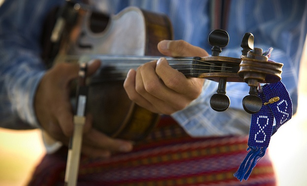 A close up photo of someone playing a violin.