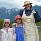 A mother and three kids dressed in costume with the mountains in the background.