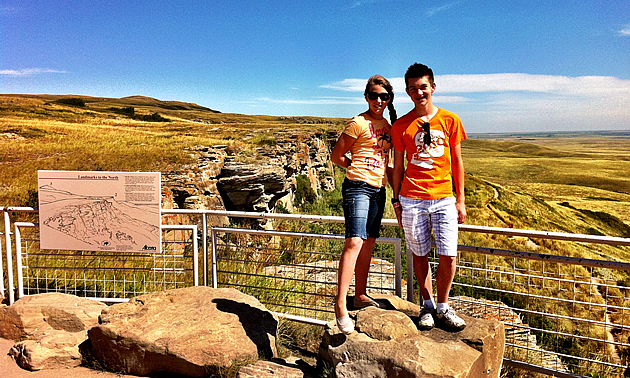 boy and a girl standing on a cliff overlooking the scenery