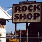 Adam Luna's Rainbow Rock Shop in Holbrook Arizona, with dinosaur sculptures and signs out front