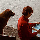 dog and lady sitting on a beach in Hudson's Hope, BC