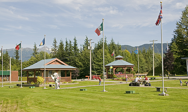 building with statue of a spirit bear and several flags in front