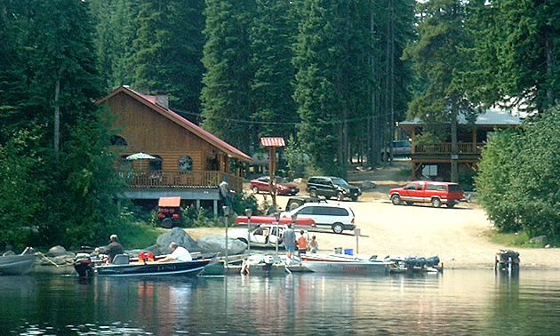 cabin in the woods with boats in the water nearby