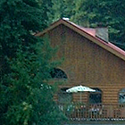 cabin in the woods with boats in the water nearby