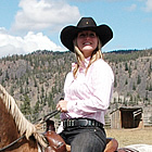 lady wearing a cowboy hat, sitting on a horse, near one of the camping areas near Merritt, BC