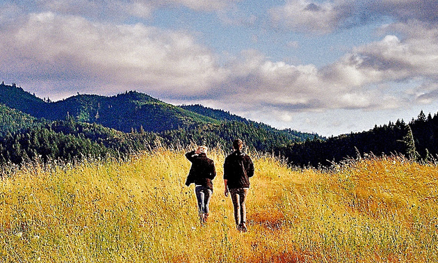 two people walking in a field