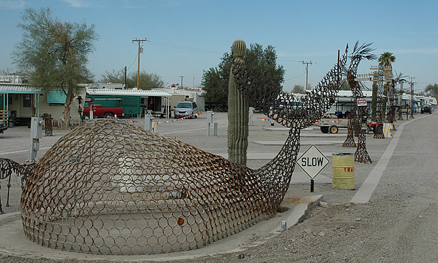 metal sculpture of a whale at the side of the road