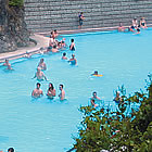 people soaking in a hot pool with trees all around