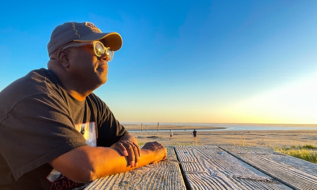 David Lee looking out at the horizon, wearing a baseball cap and t-shirt.