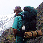 man standing on a rocky ledge overlooking a hiking trail